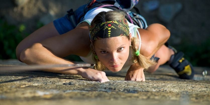 Vertical image of woman doing exercise on the mountain