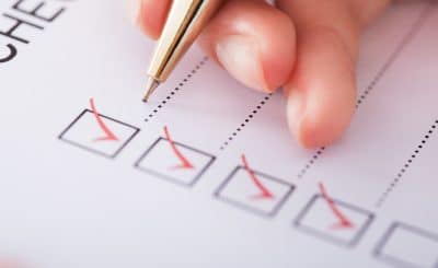 Cropped image of businesswoman writing on checklist