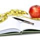 Journal, tape measure and apple - diet concept