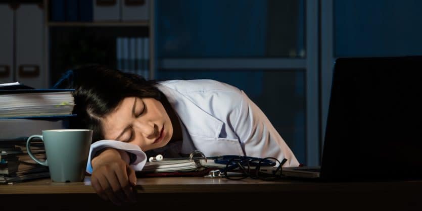 doctor feel tired sleeping on desk of clinic. beautiful mixed race asian chinese woman model. medical and health concept