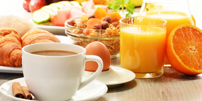 Breakfast with coffee, orange juice, croissant, egg, vegetables and fruits