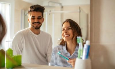 Portrait of a young couple brushing teeth in the bathroom.