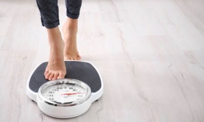 Top view of feet on weighing scale. Women weigh on a weight balance scale  after diet control. Healthy body weight. Weight and fat loss concept. Weight  measure machine. Body Mass Index or