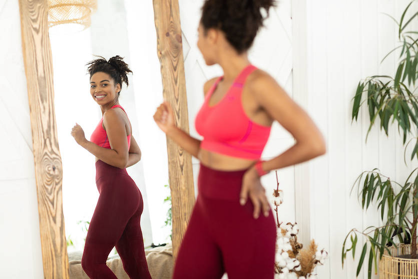 Woman After Weight-Loss Looking In Mirror