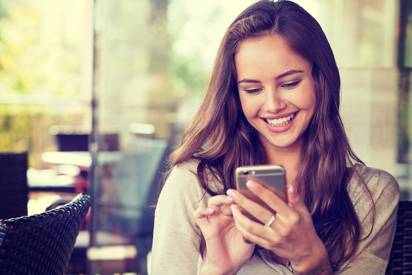 woman in cafe using her mobile phone